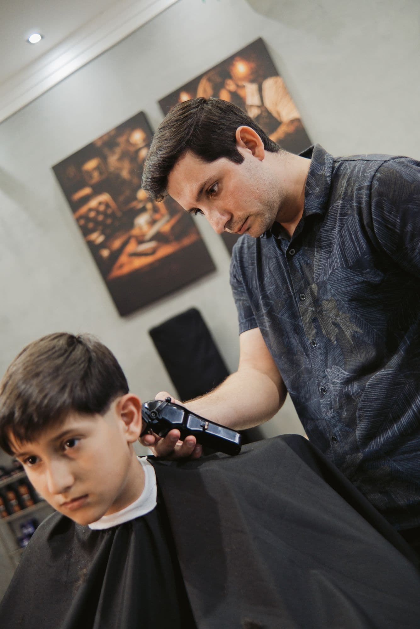 Barbeiro aplicando produto de acabamento no cabelo do cliente